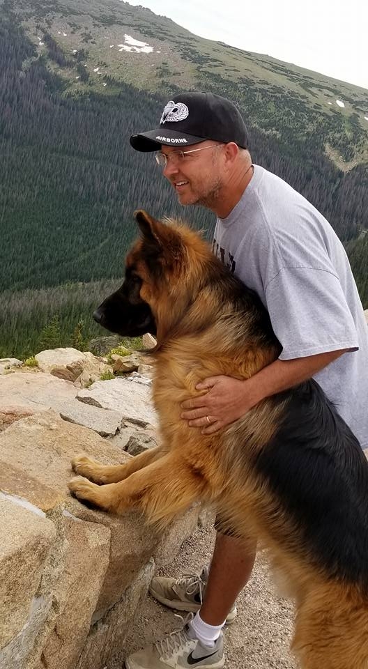 Dave Stanford and his German Shepherd Dog Peyton standing looking over a mountain overlook